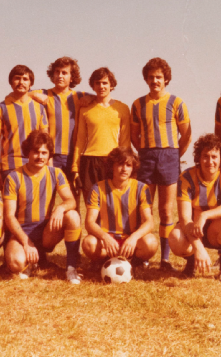 Men's soccer team posing for photo on a field