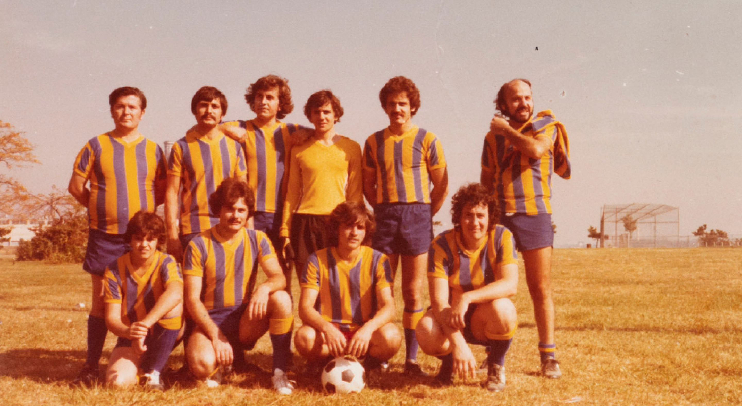 Men's soccer team posing for photo on a field