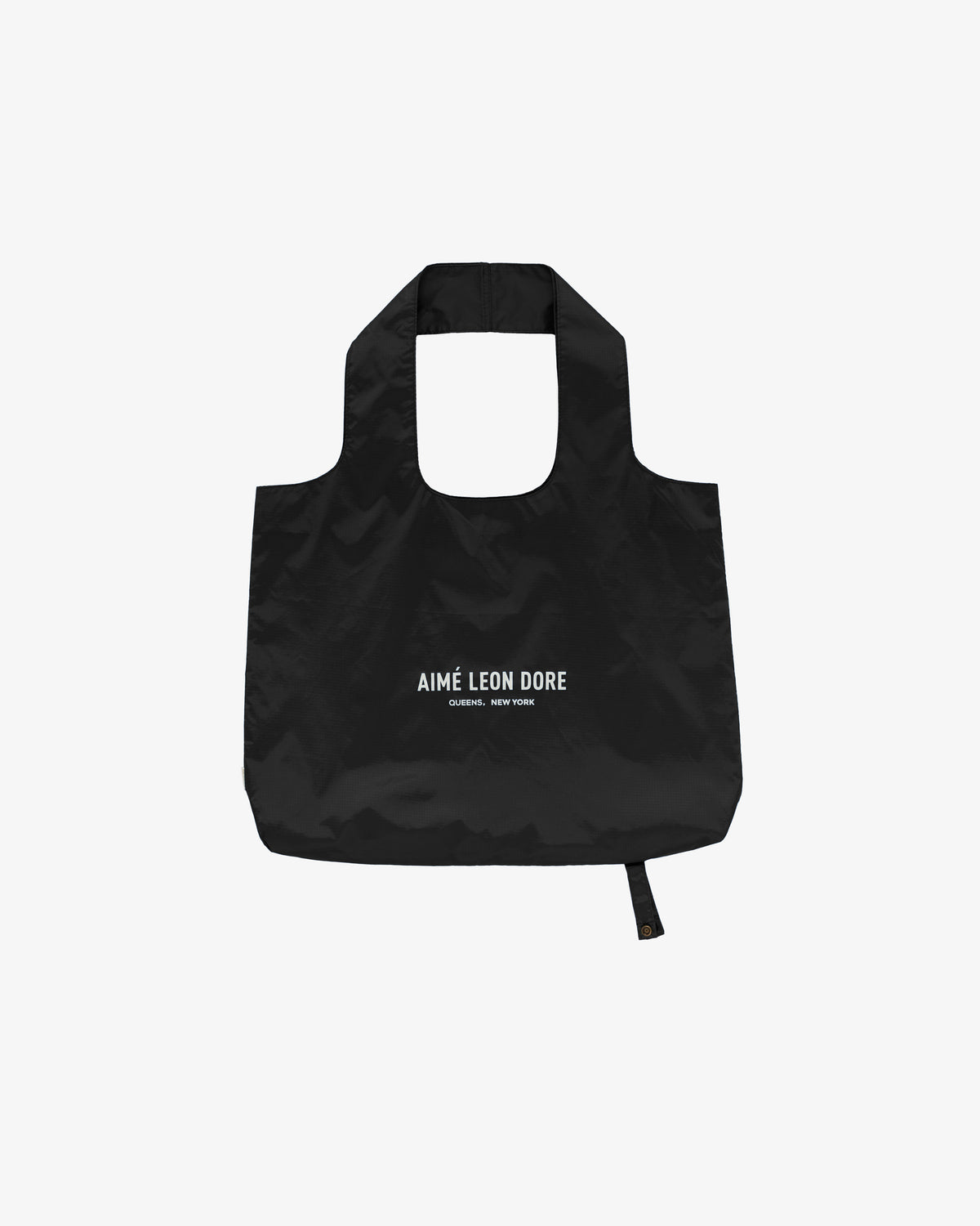 Black Packable Tote with AIMÉ LEON DORE CORNER, NEW YORK text printed in white on the front.