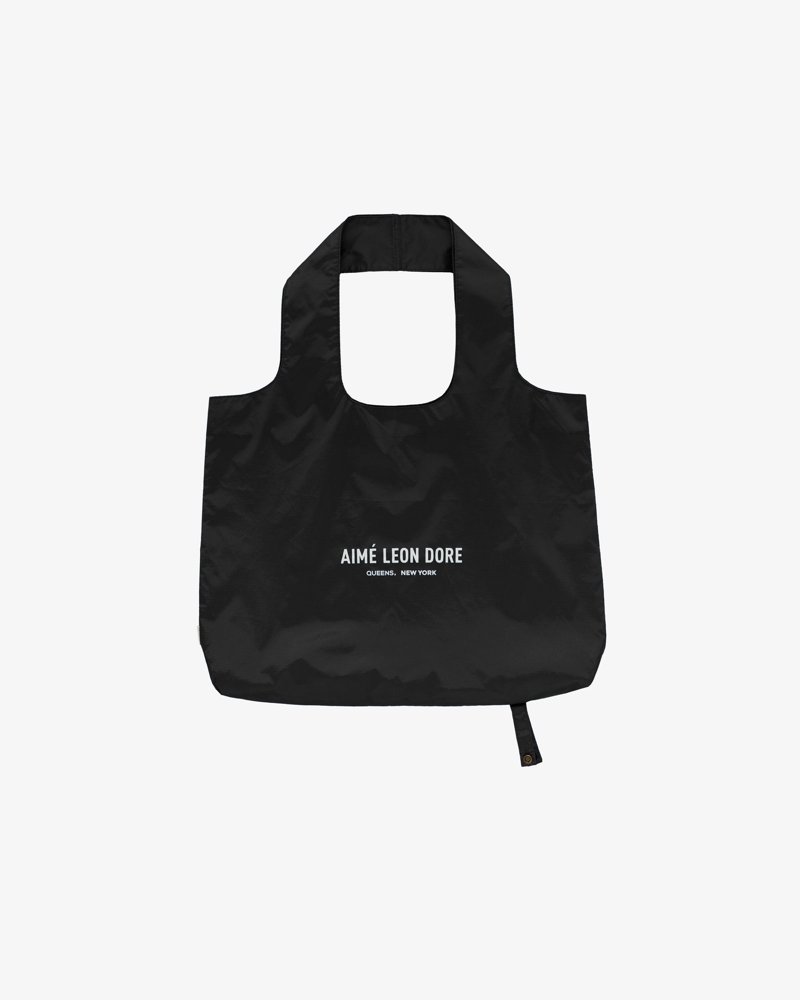Black Packable Tote with AIMÉ LEON DORE CORNER, NEW YORK text printed in white on the front.