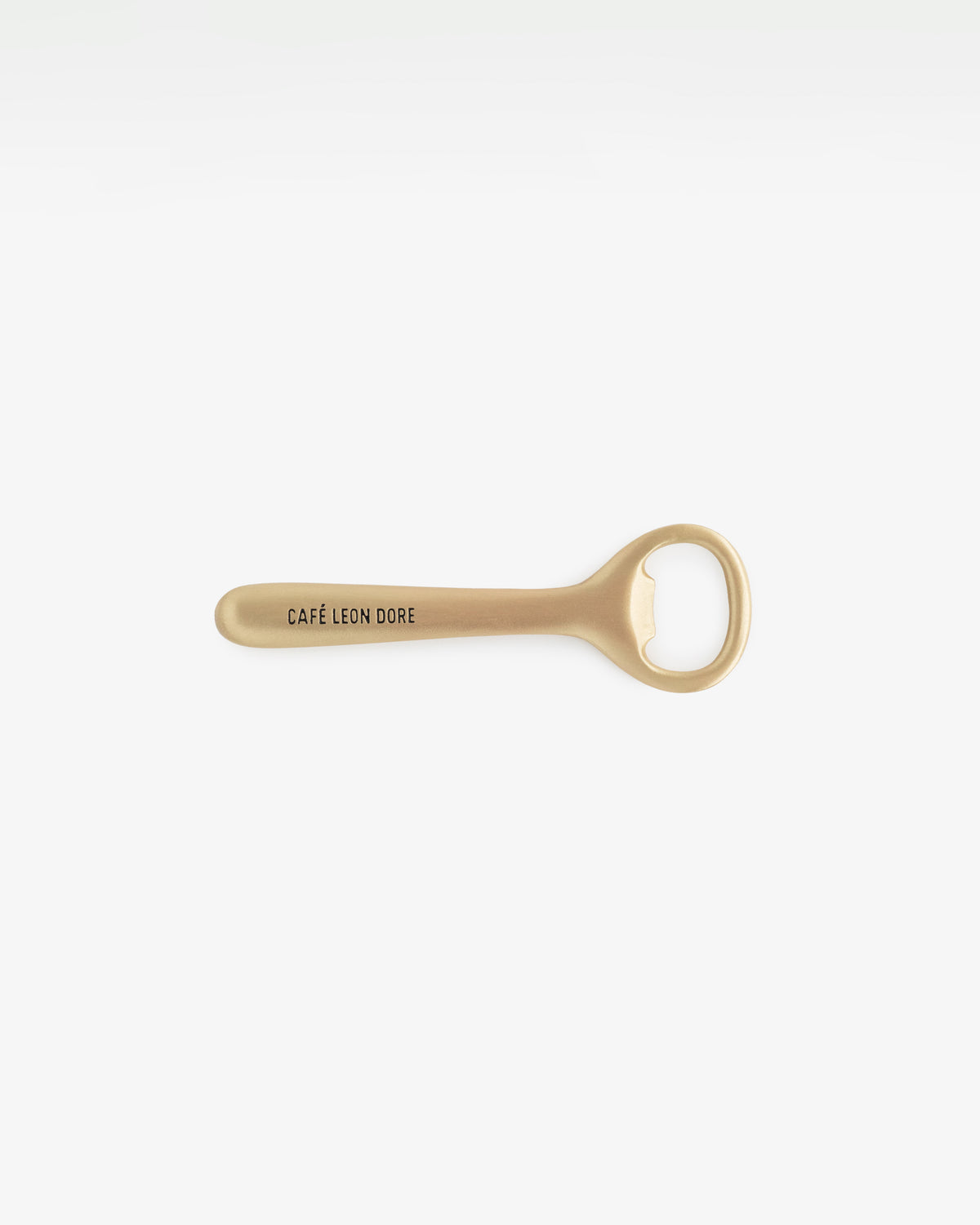Café Leon Dore Bottle Opener in gold with logo on handle, displayed against a plain white background.