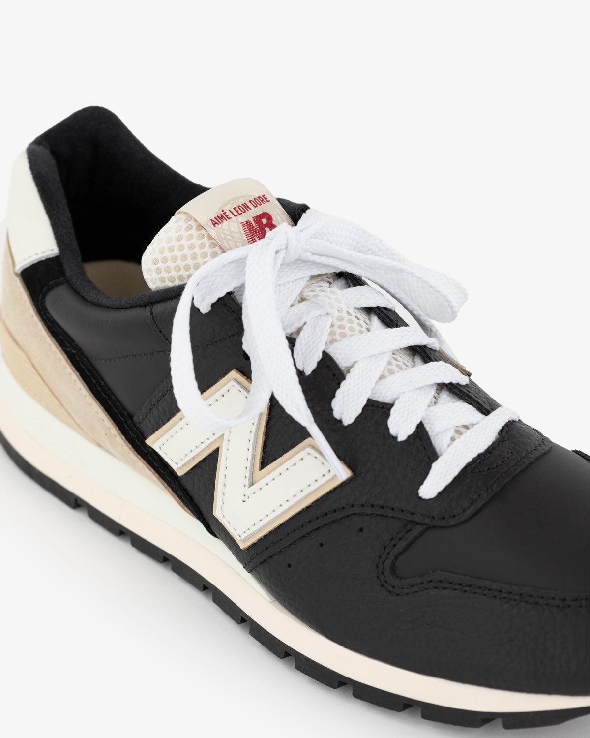 ALD / NB Made in USA 996 sneaker, black and white with white laces and beige heel detail on a white background.