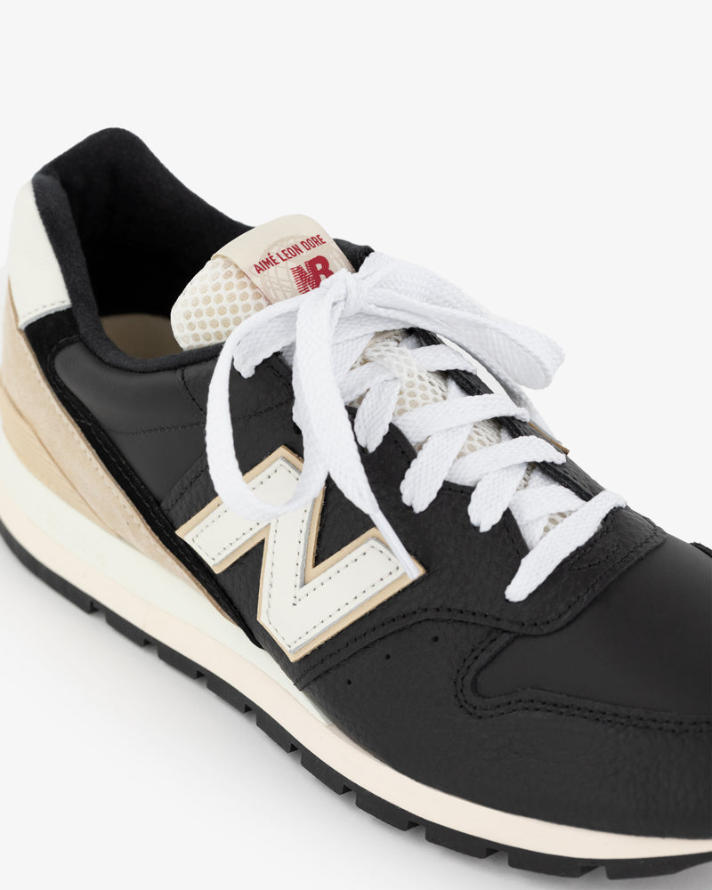 ALD / NB Made in USA 996 sneaker, black and white with white laces and beige heel detail on a white background.
