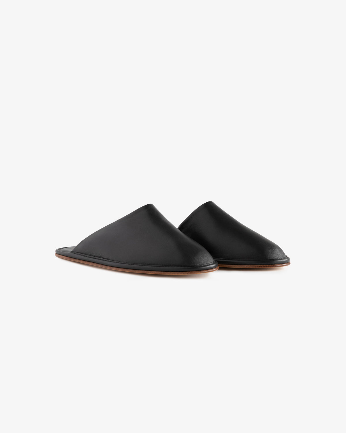 A pair of Leather Travel Slippers in black leather with brown soles on a white background.