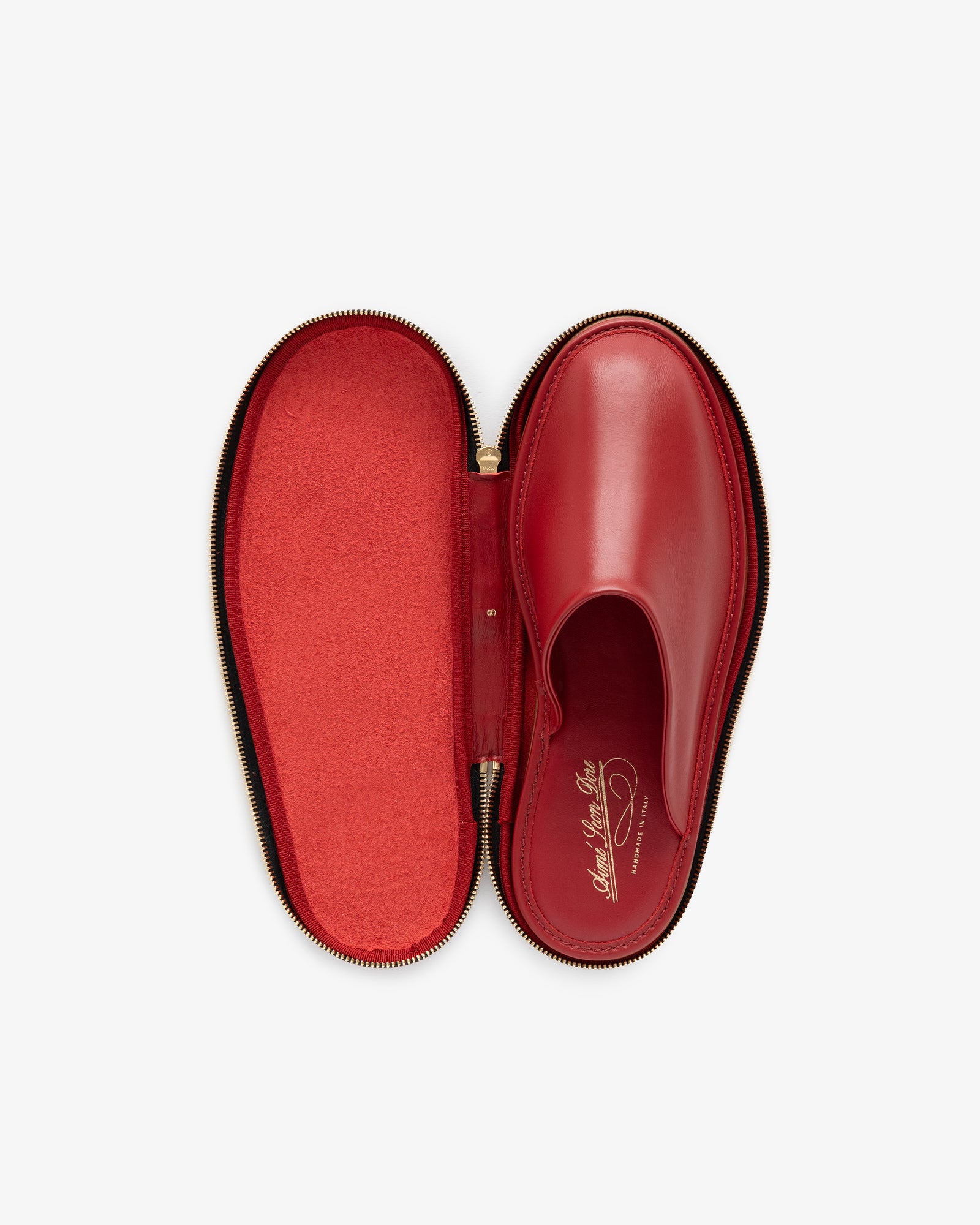 A Leather Travel Slipper in red leather comes in a matching red, oval zippered case, both shown open from above.