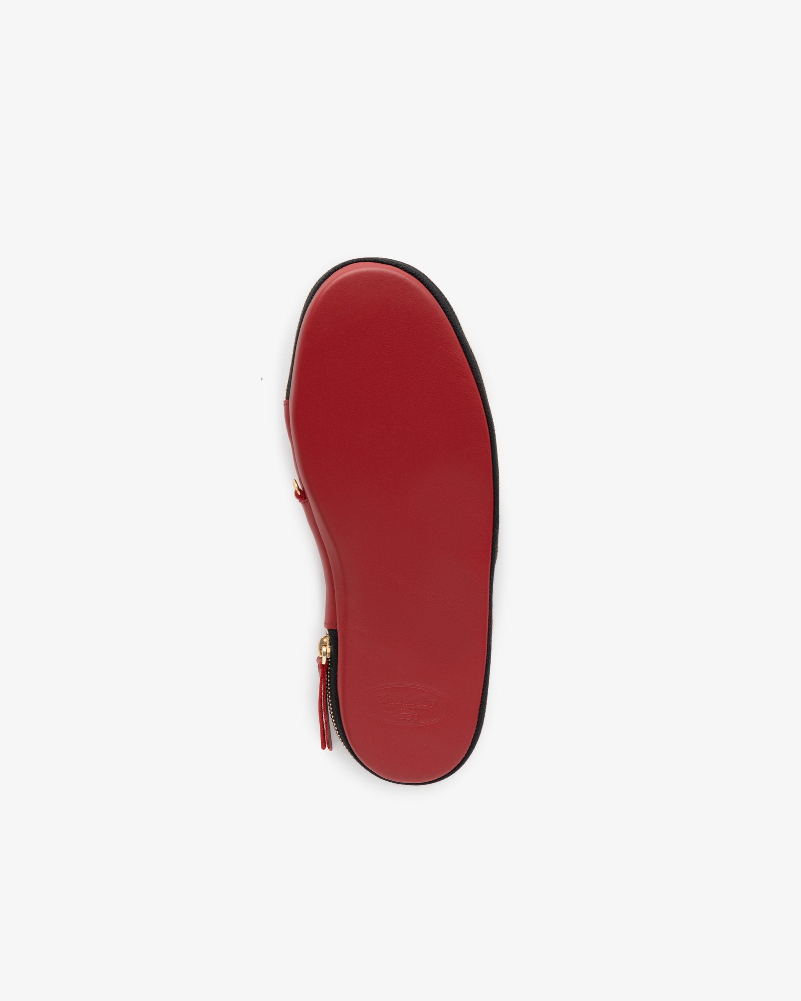 Leather Travel Slipper with red sole, zipper detail, and gold hardware, shown bottom-up on a white background.