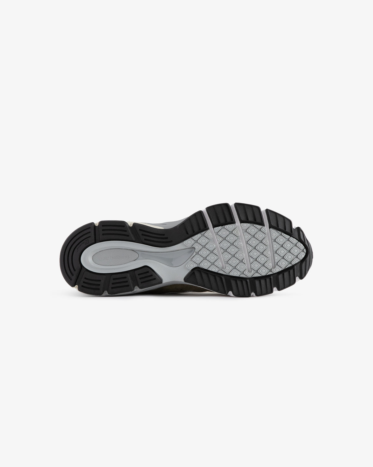 The image shows the black and gray rubber sole of the ALD / New Balance 990v4 sneaker, viewed from the bottom.