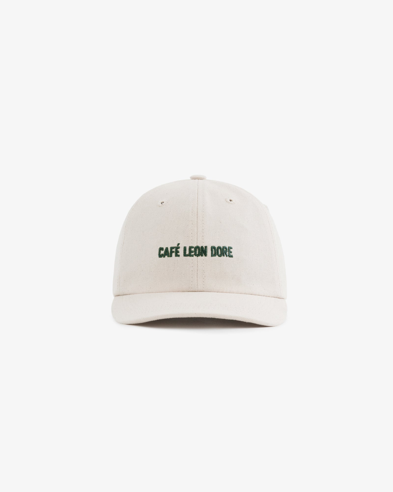 The Café Leon Dore Hat is a beige baseball cap with green embroidered branding on the front, shown on white.