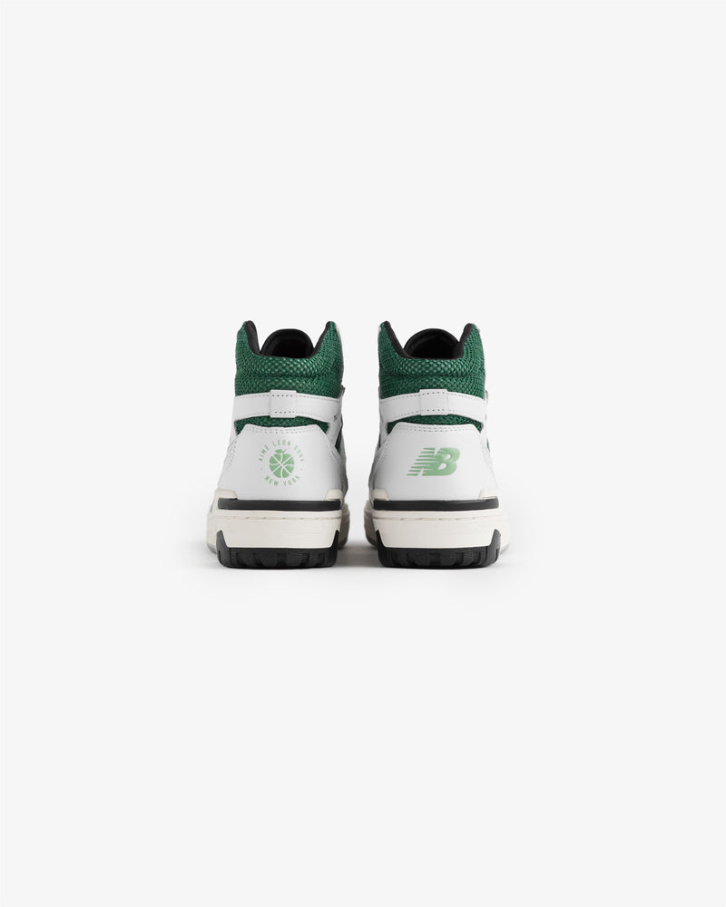 A pair of ALD / New Balance 650R sneakers in white and green shown from the back on a plain white background.