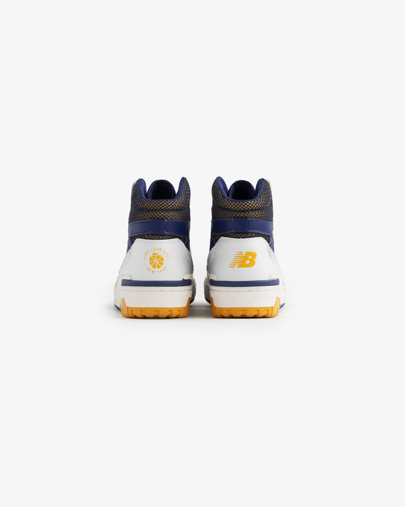 Back view of ALD / New Balance 650R sneakers in white, blue, and yellow with heel logos on a white background.