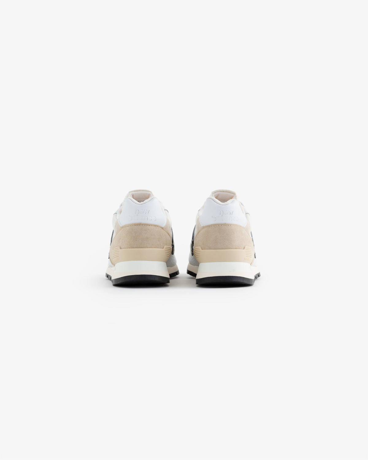 ALD / NB Made in USA 996 sneakers in white, beige, and black, seen from the back on a plain white background.