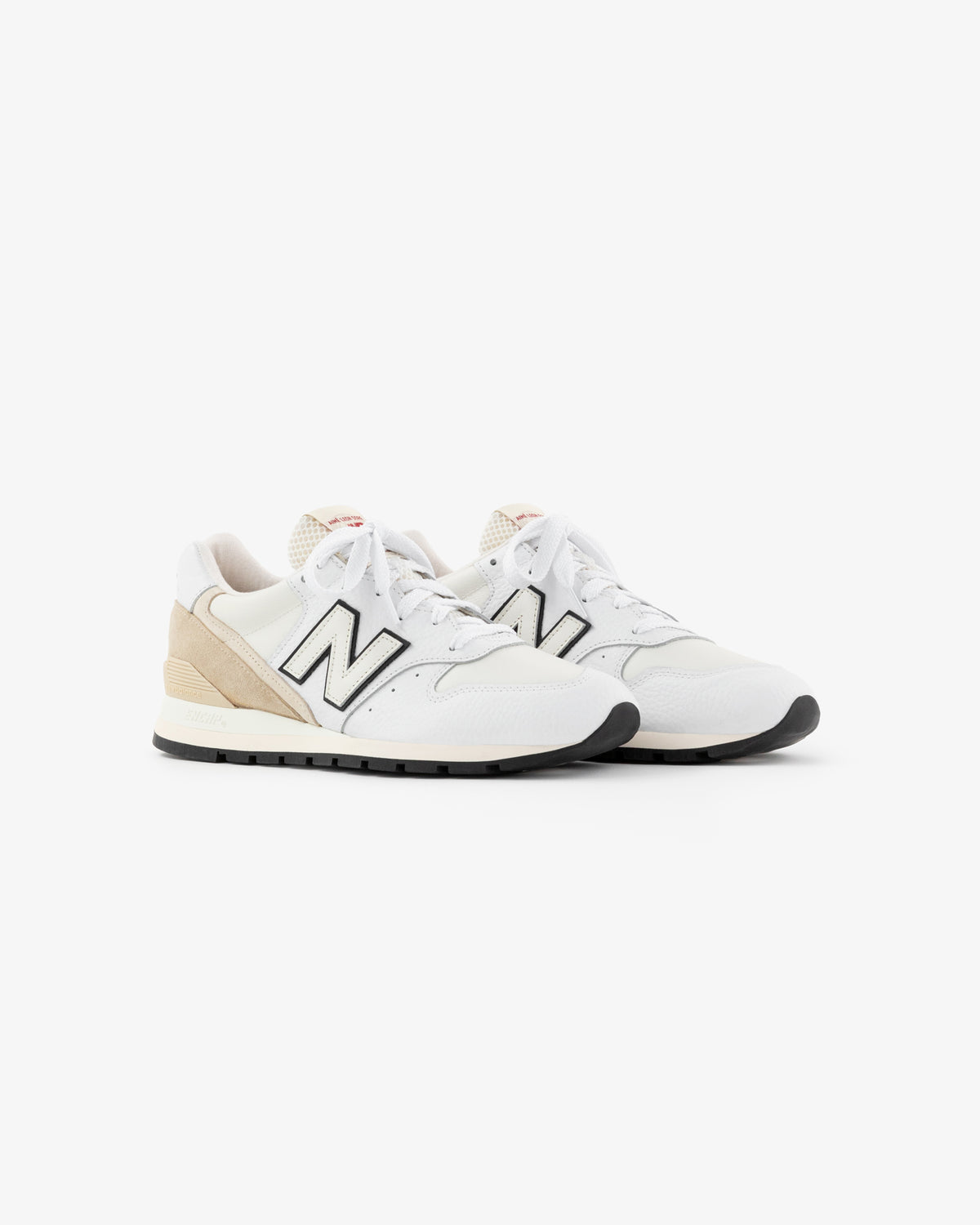 ALD / NB Made in USA 996: white and beige sneakers with black accents, white laces, and a beige heel detail.