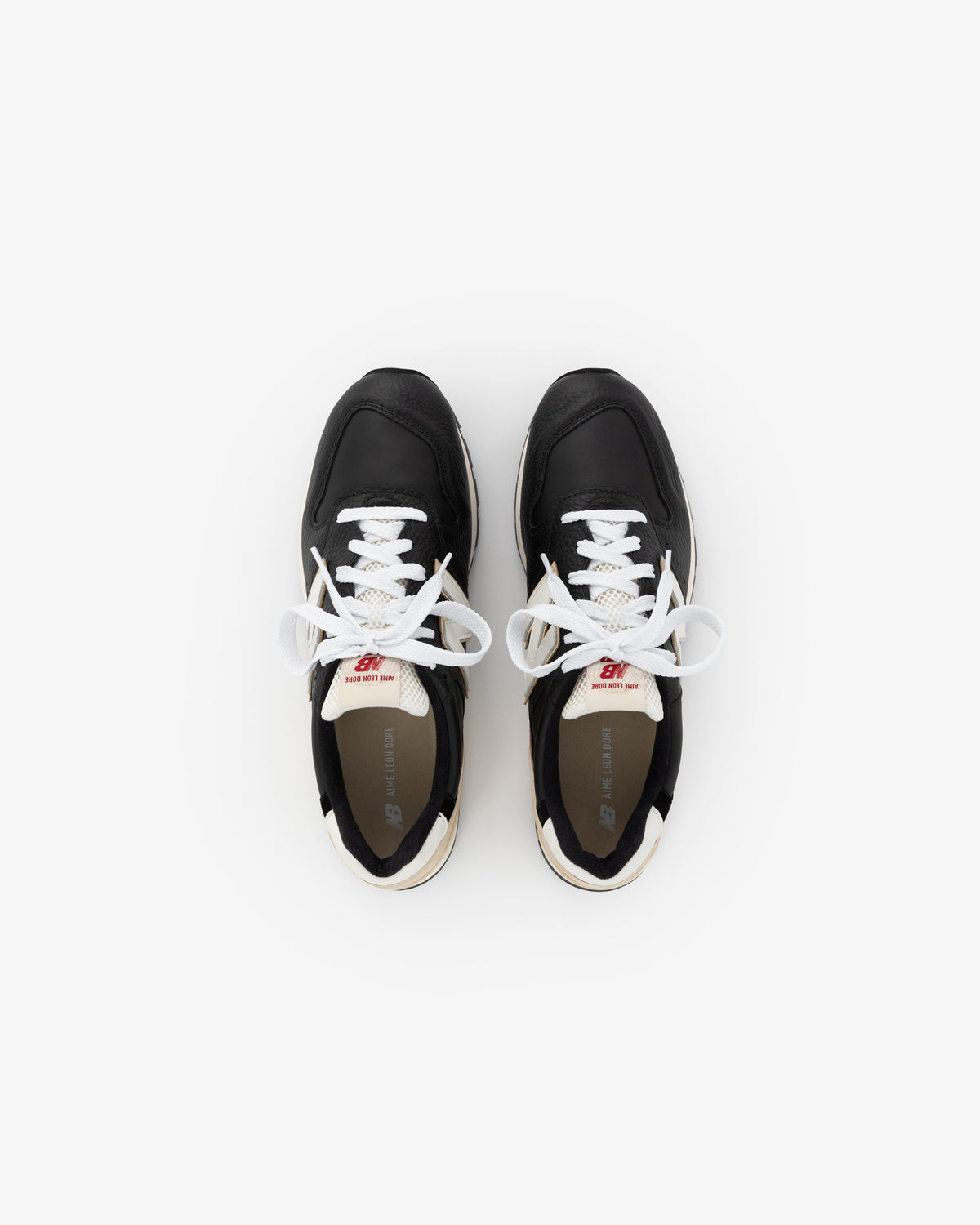 The ALD / NB Made in USA 996 sneakers are black with white laces, shown from above on a white background.