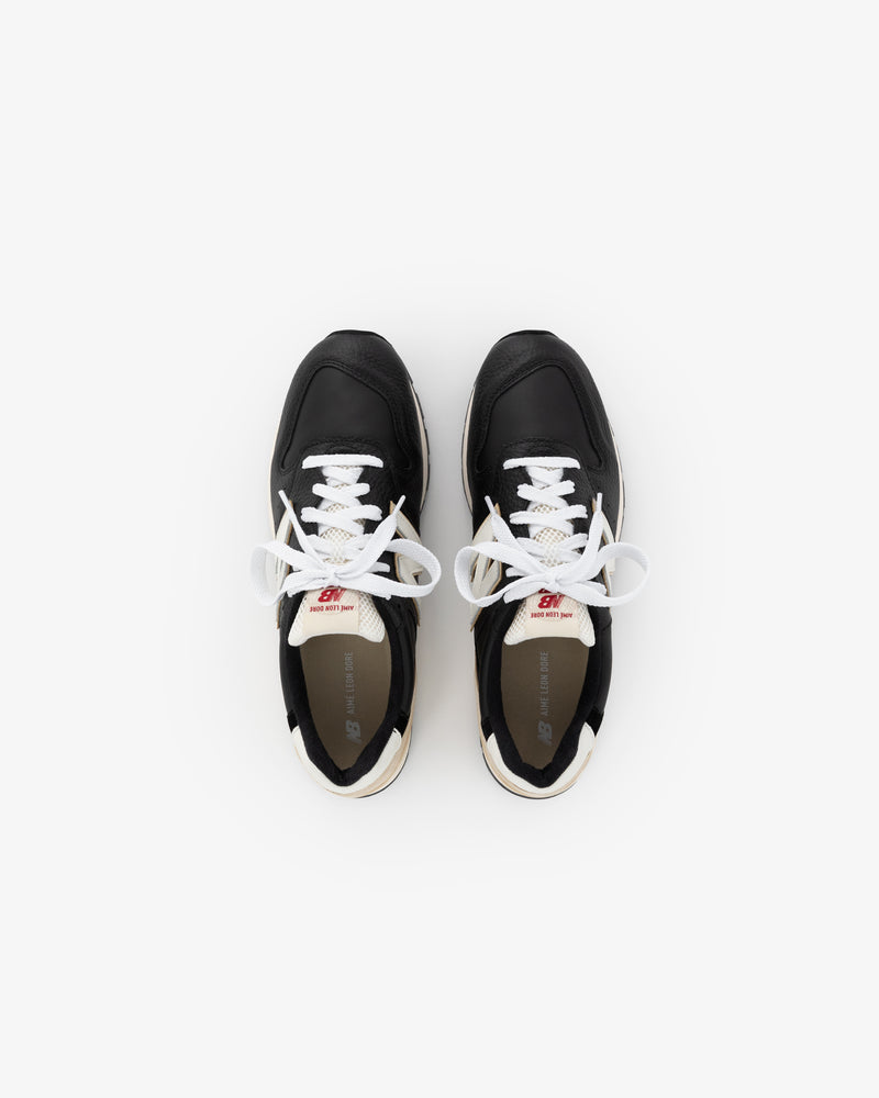 The ALD / NB Made in USA 996 sneakers are black with white laces, shown from above on a white background.