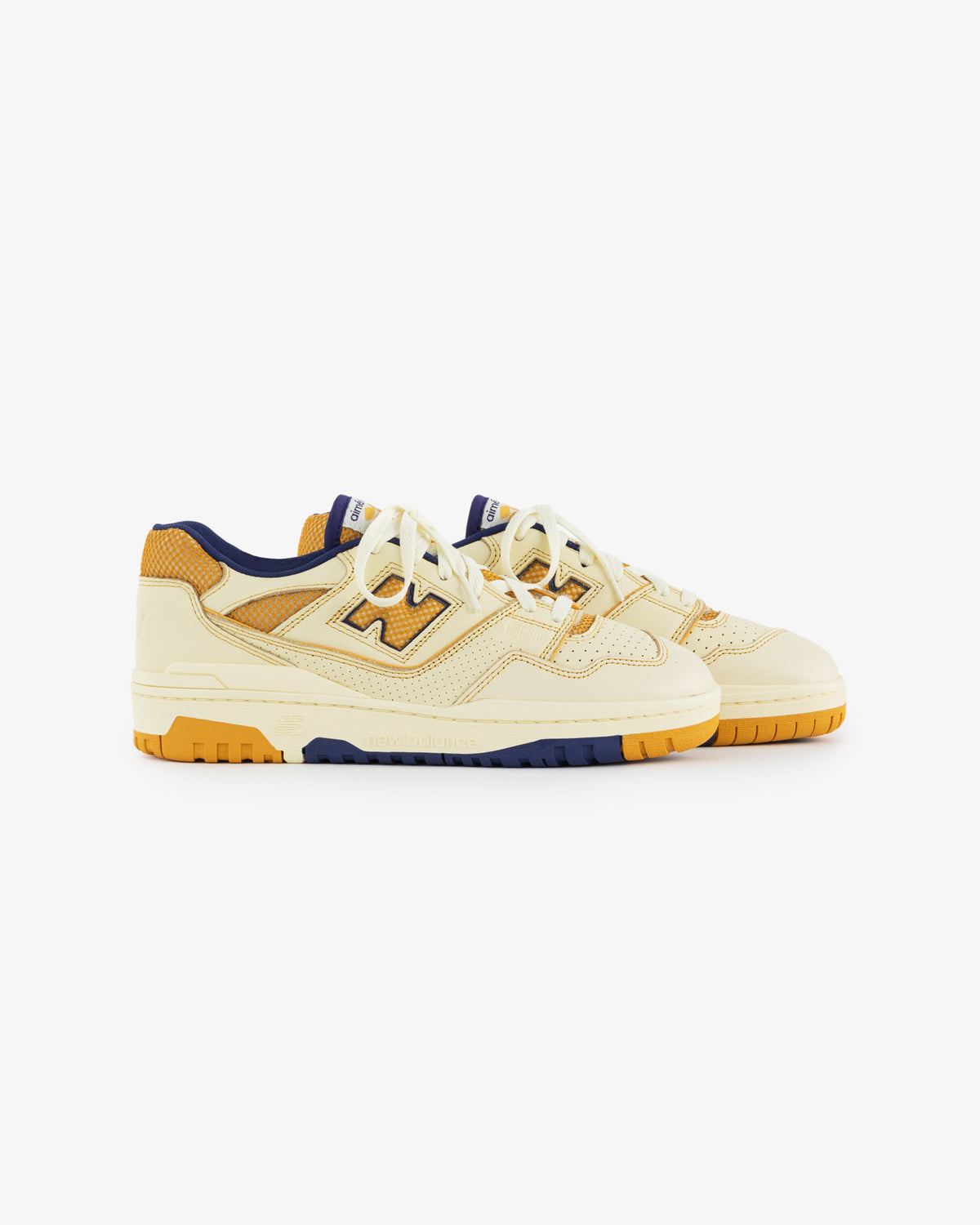 ALD / NB P550 Basketball Oxfords in yellow and orange with navy accents, white laces on a white background.