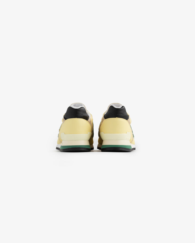New Balance Made in USA 996 sneakers in yellow and black, shown from the back on a plain white background.