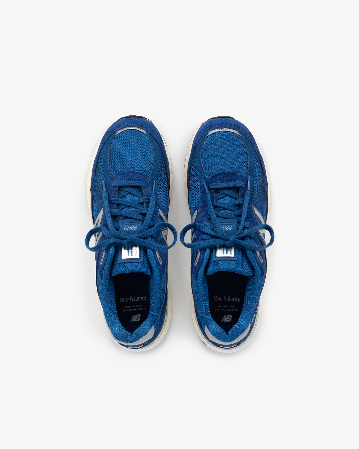 The ALD / NB Made in USA 990v4 sneakers in blue, seen from above on a white background.