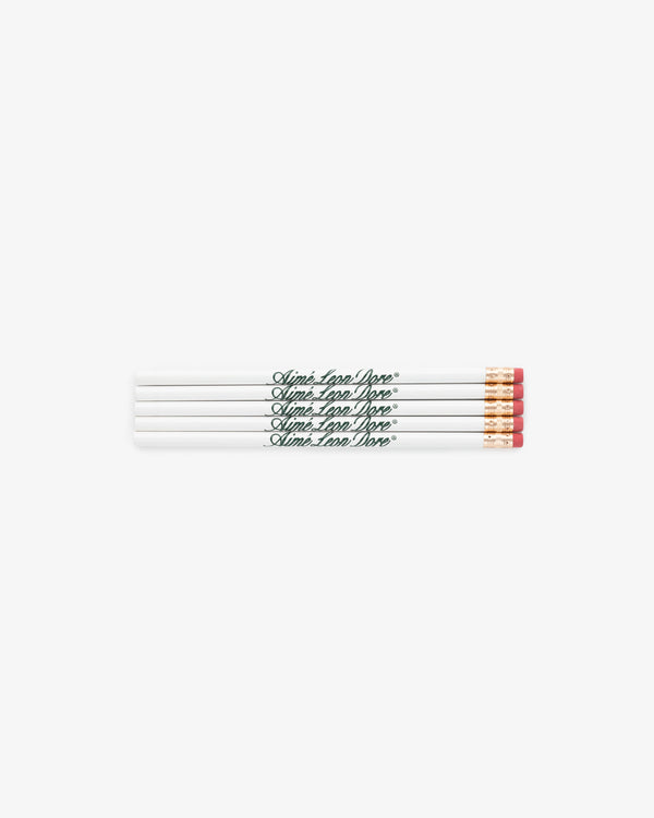 Four TEST060 pencils, white with pink erasers and green “Aimé Leon Dore” text, placed side by side.