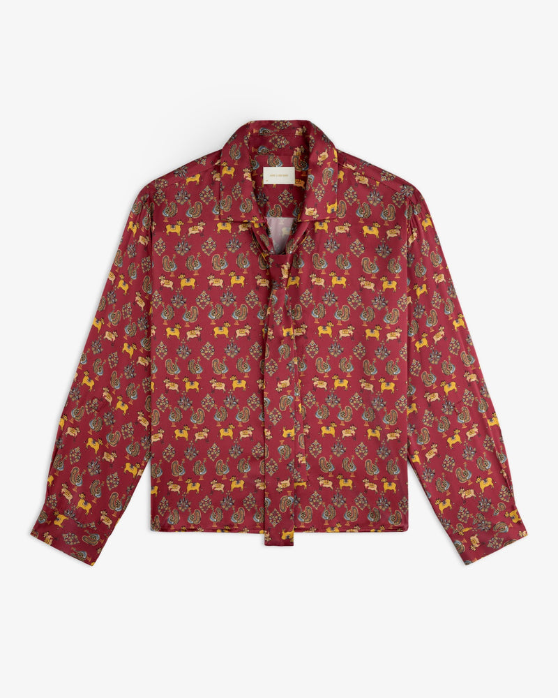 Archival Print Silk Tie Neck Blouse in deep red with an all-over small animal and floral pattern and a tie neck.