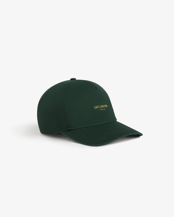 Café Leon Dore Logo Hat in dark green with small yellow front text, shown on a plain white background.
