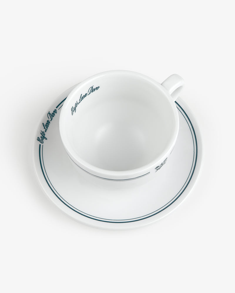 Set of 6 Café Leon Dore Cappuccino Cups & Saucers with blue trim and script, shown from above on white background.