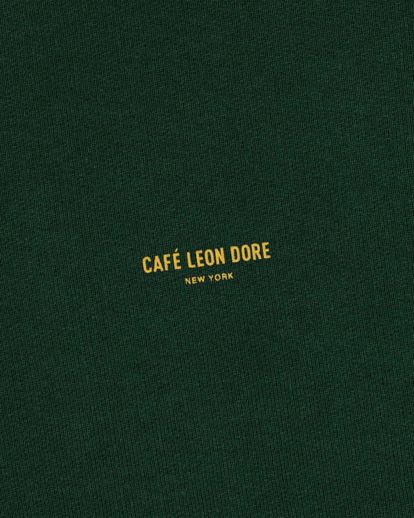 Dark green Café Leon Dore Crewneck Sweatshirt with small yellow “CAFÉ LEON DORE NEW YORK” centered on the front.