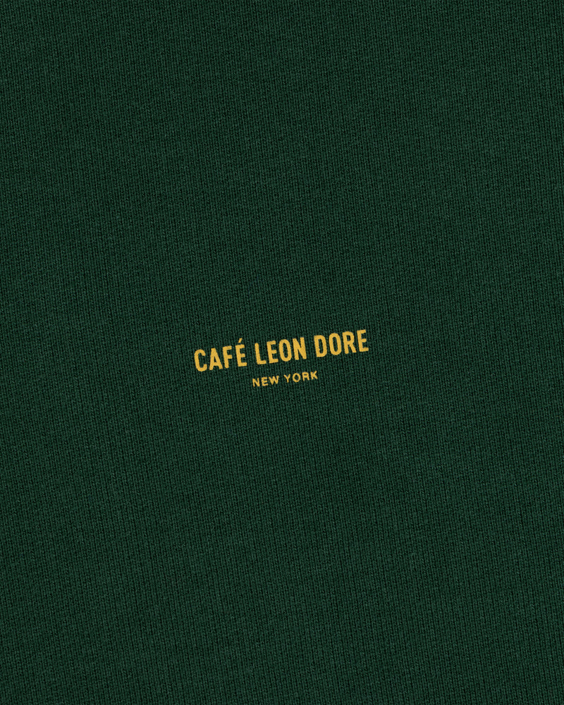 Dark green Café Leon Dore Crewneck Sweatshirt with small yellow “CAFÉ LEON DORE NEW YORK” centered on the front.