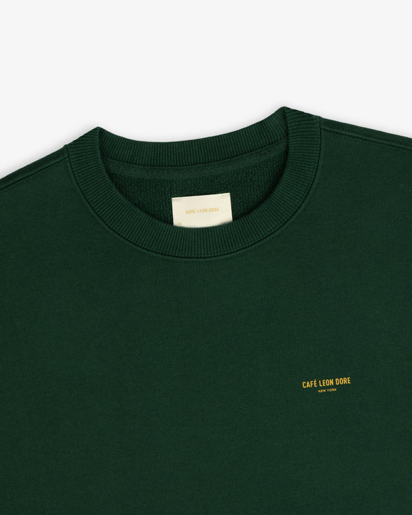 Dark green Café Leon Dore Crewneck Sweatshirt with yellow New York chest text.