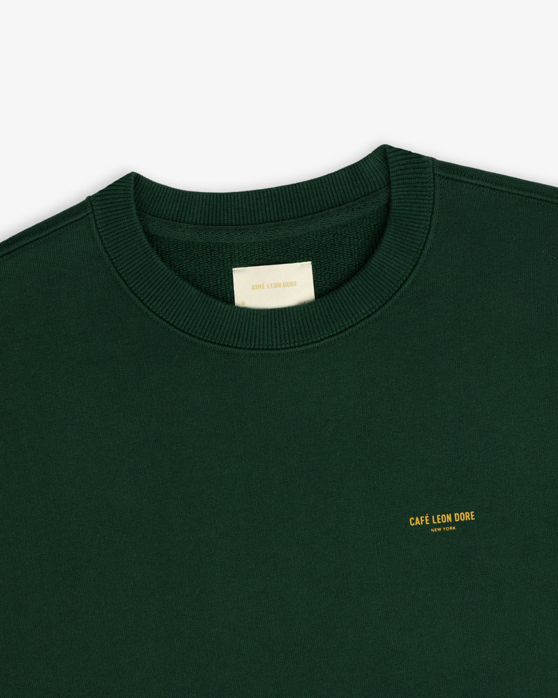 Dark green Café Leon Dore Crewneck Sweatshirt with yellow New York chest text.