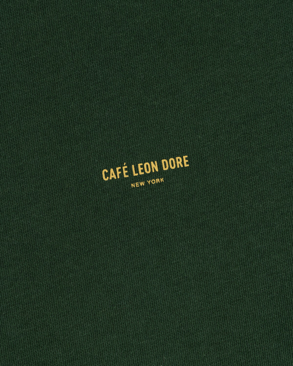 Green Café Leon Dore Logo Tee with yellow “CAFÉ LEON DORE NEW YORK” text centered on the front.