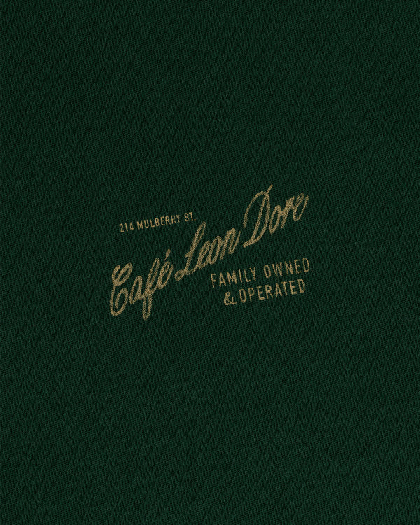 Dark green Café Leon Dore Mulberry Tee with gold text: 214 Mulberry St., Family Owned & Operated.