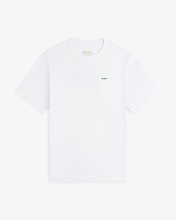 Café Leon Dore Caricature Tee: white short-sleeve shirt with small text on the left chest.