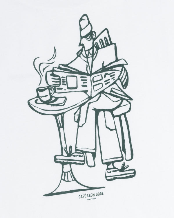Line drawing on tee: person reads newspaper at table with coffee; text below says CAFÉ LEON DORE NEW YORK.