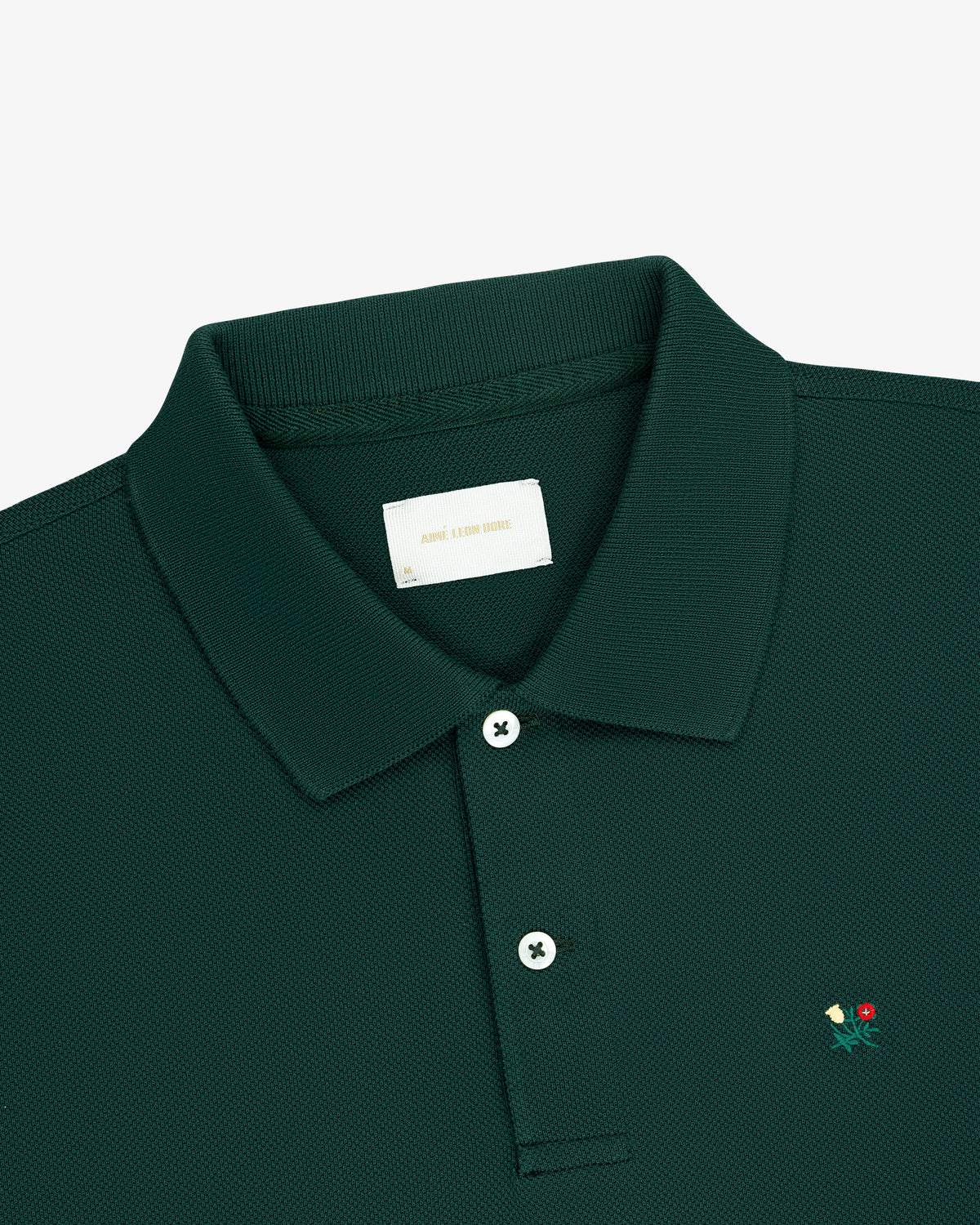 Long-Sleeve Crest Piqué Polo in dark green features a small chest flower and a white inner collar label.