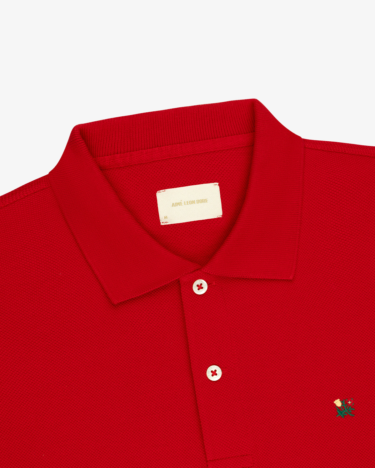 Long-Sleeve Crest Piqué Polo in red with a collar, two buttons, and a small green and yellow chest logo.
