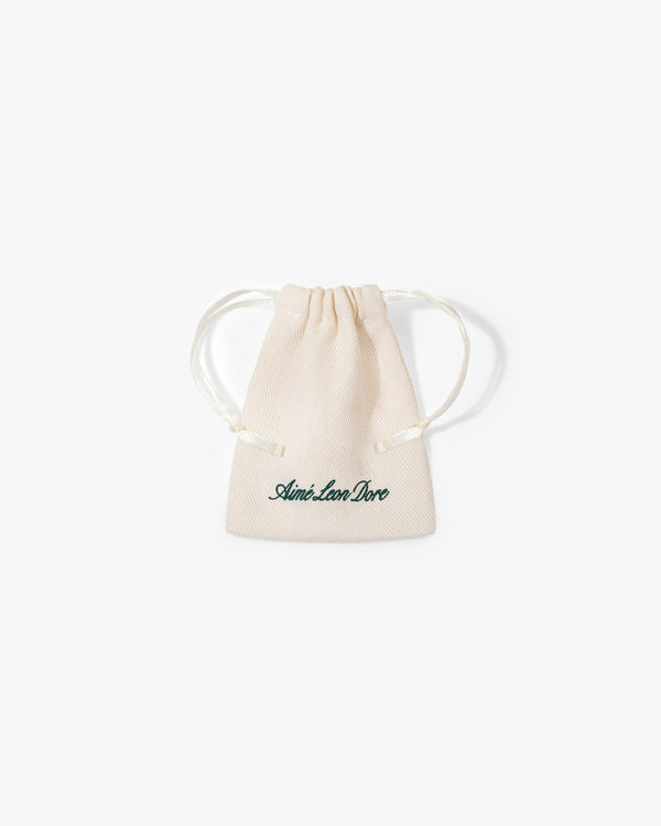 A small beige drawstring pouch with "Queens Crest Penny" written in green script on the front.