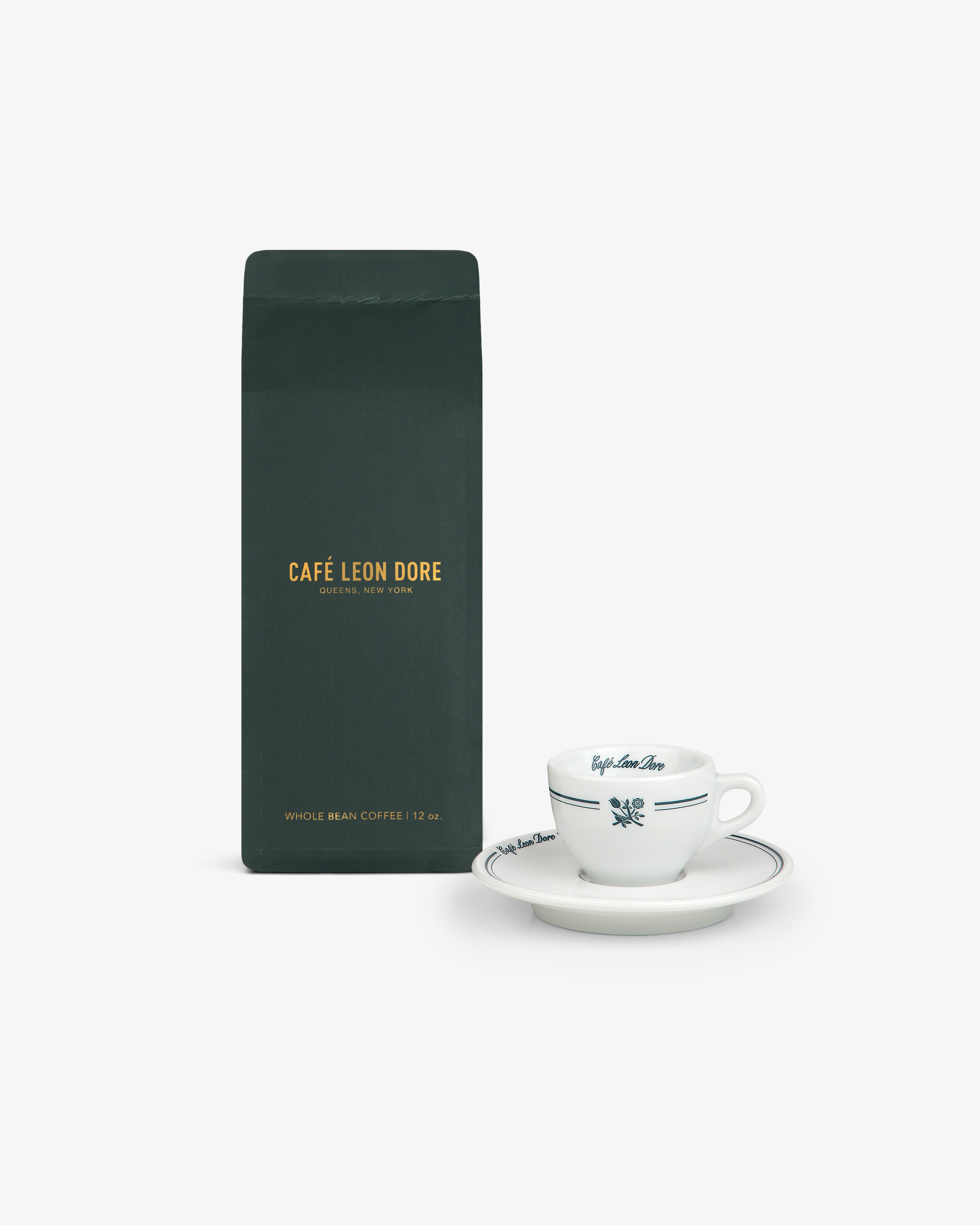 A dark green ALD Espresso Beans bag next to a white espresso cup and saucer on a white background.