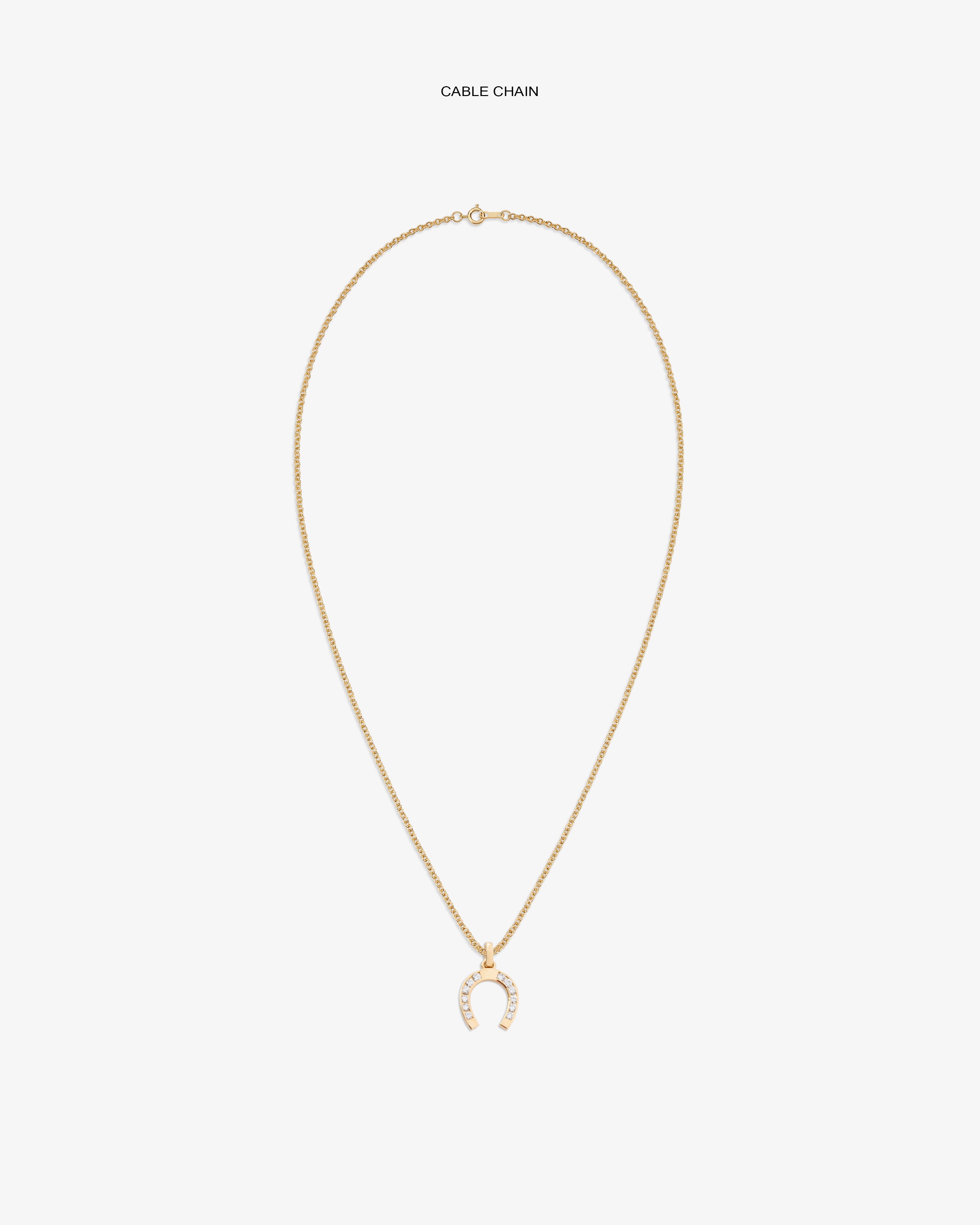 Diamond Horseshoe Pendant on gold chain, featuring small clear stones, shown against a white backdrop.
