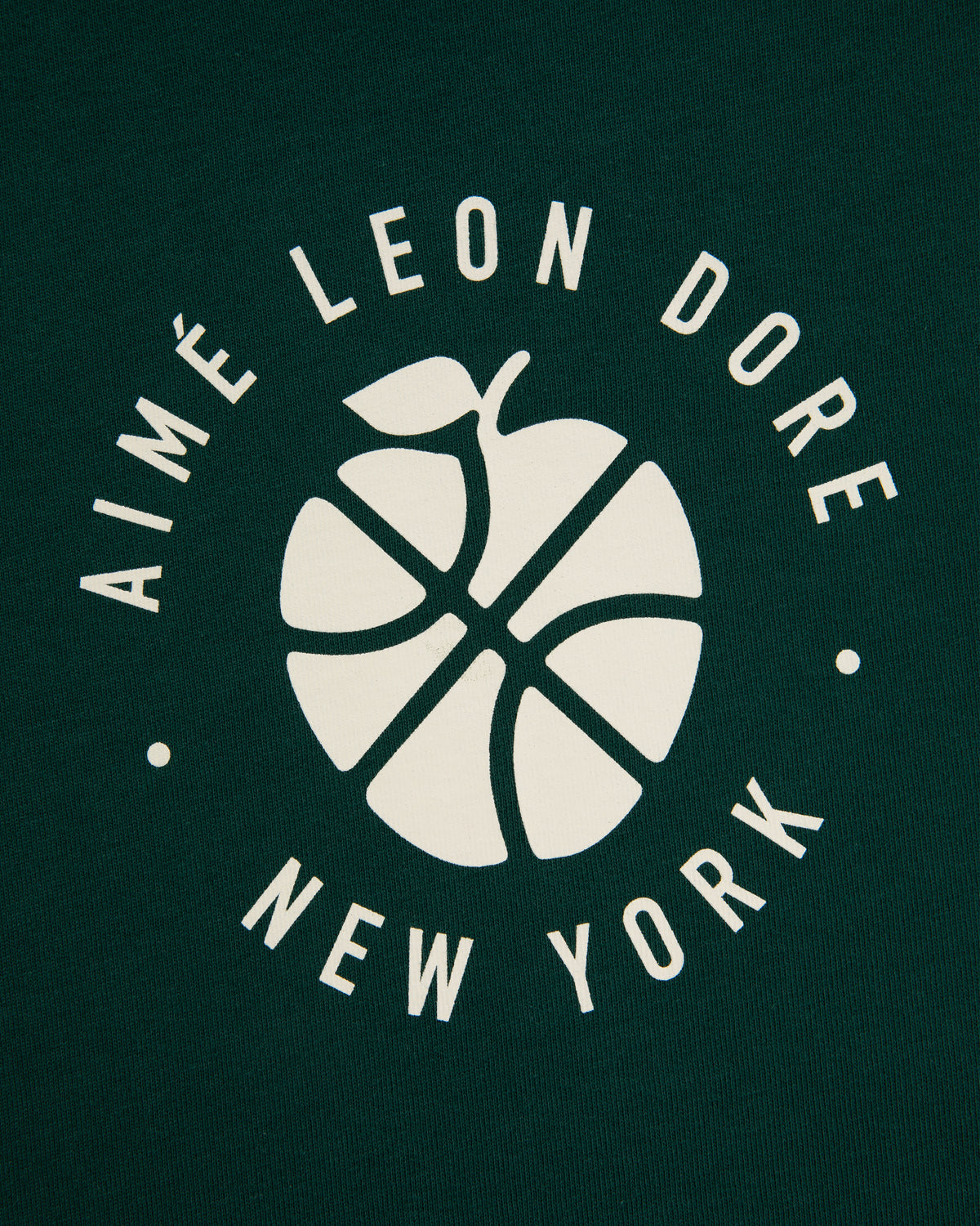 White basketball-apple logo and "AIMÉ LEON DORE NEW YORK" on dark green ALD / New Balance SONNY NY Long-Sleeve Tee.