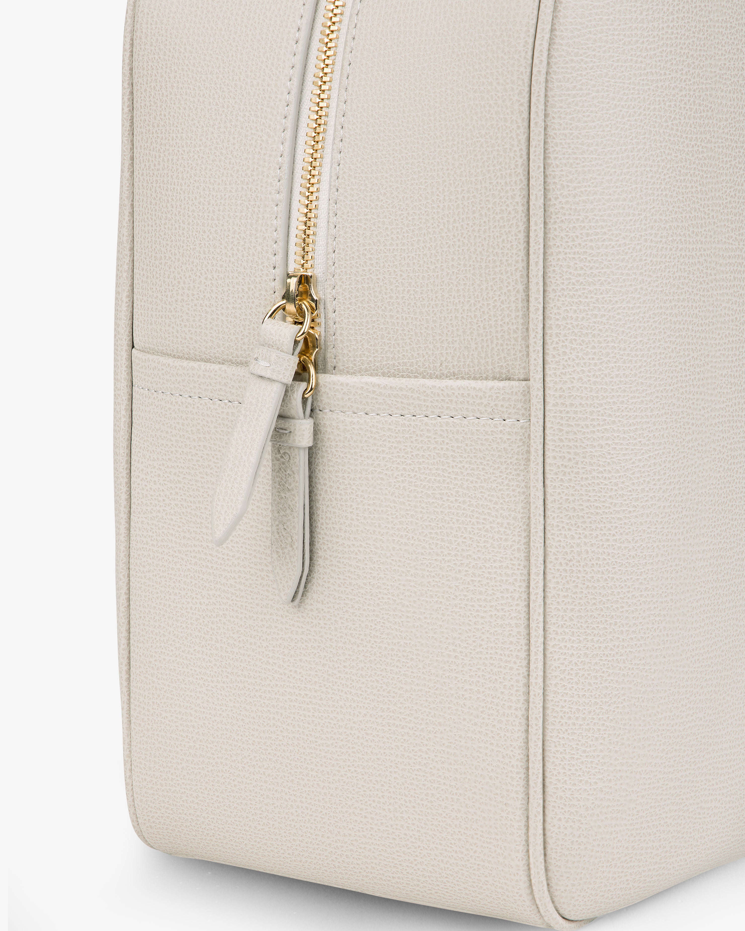 Close-up of Full Grain Leather Briefcase Duffle in light beige with a gold zipper and a front pocket detail.