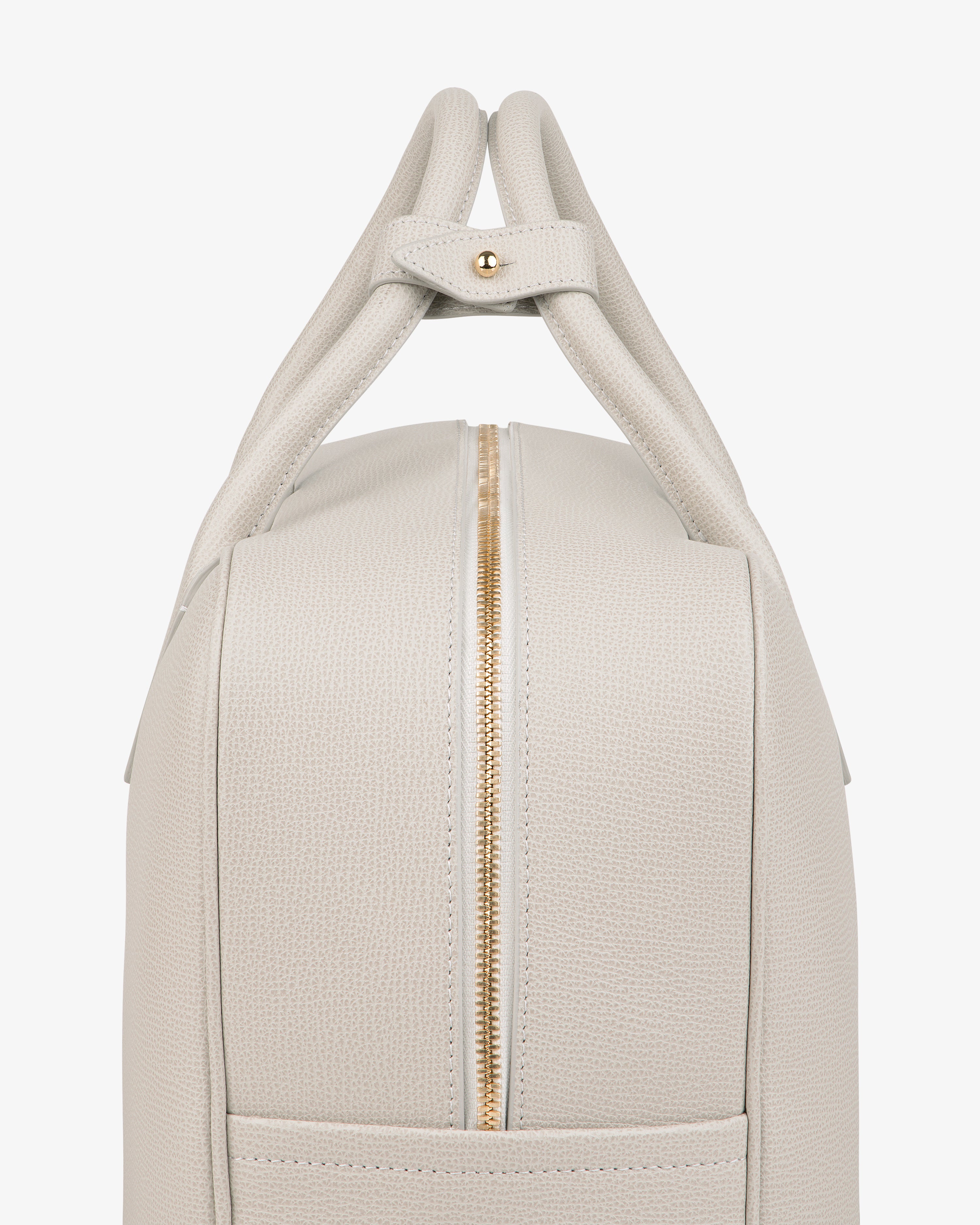 Side view of the Full Grain Leather Briefcase Duffle in light beige textured leather with gold zipper and double handles.