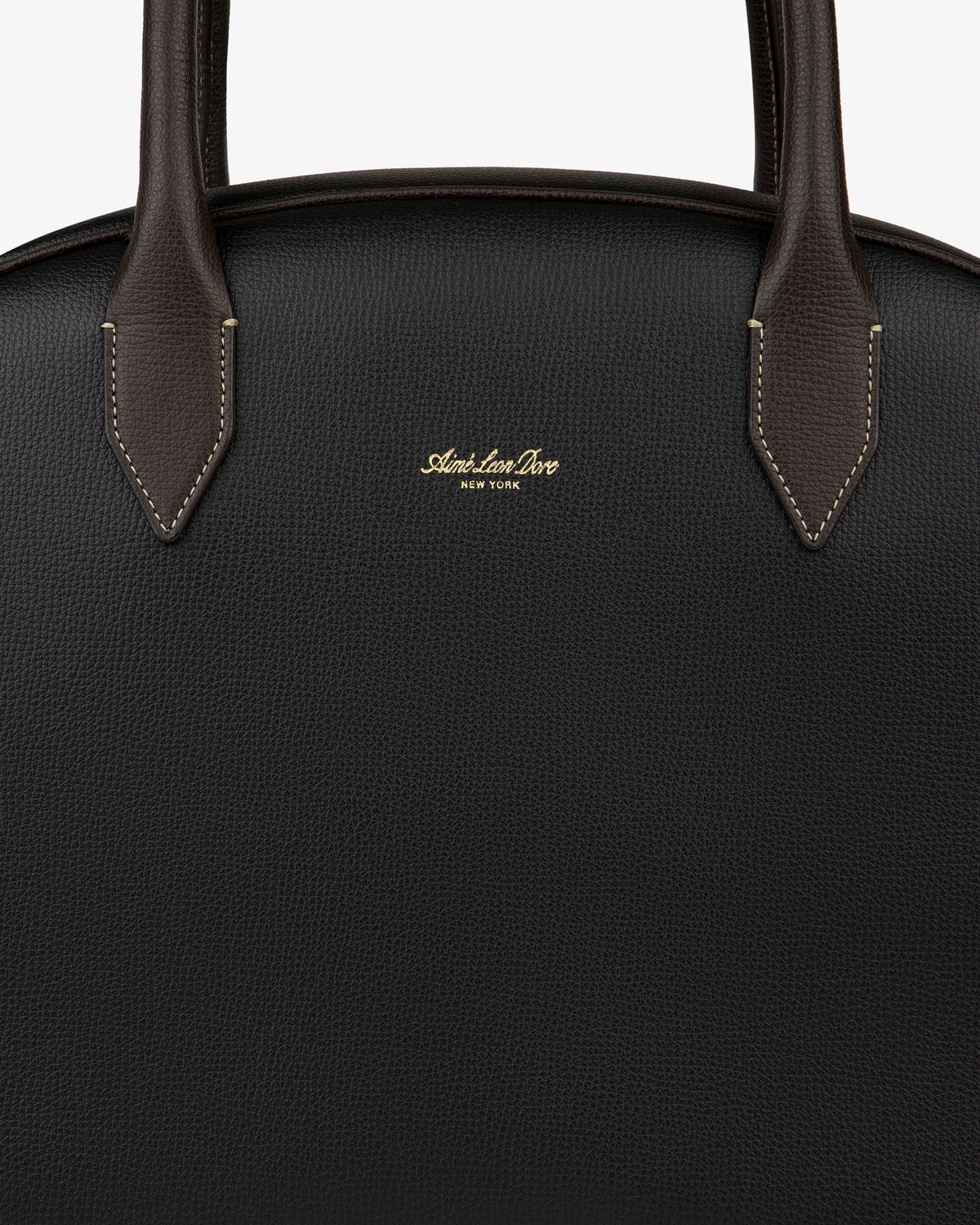 Close-up of a black Full Grain Leather Crescent Shoulder Bag with brown handles and gold Sloan & Sons, New York branding.