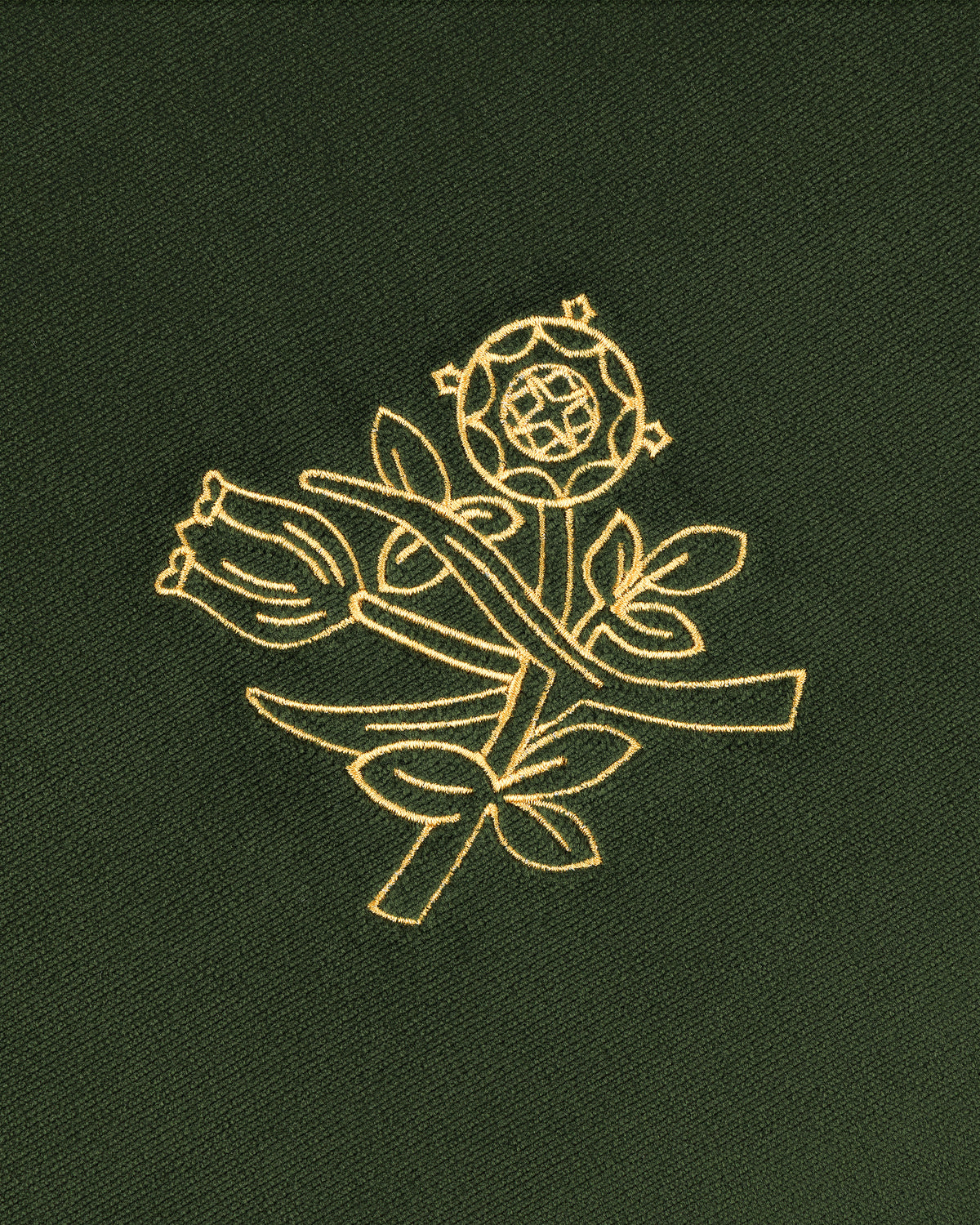 Queens Crest Throw Pillow with gold embroidered rose and floral design on dark green fabric.