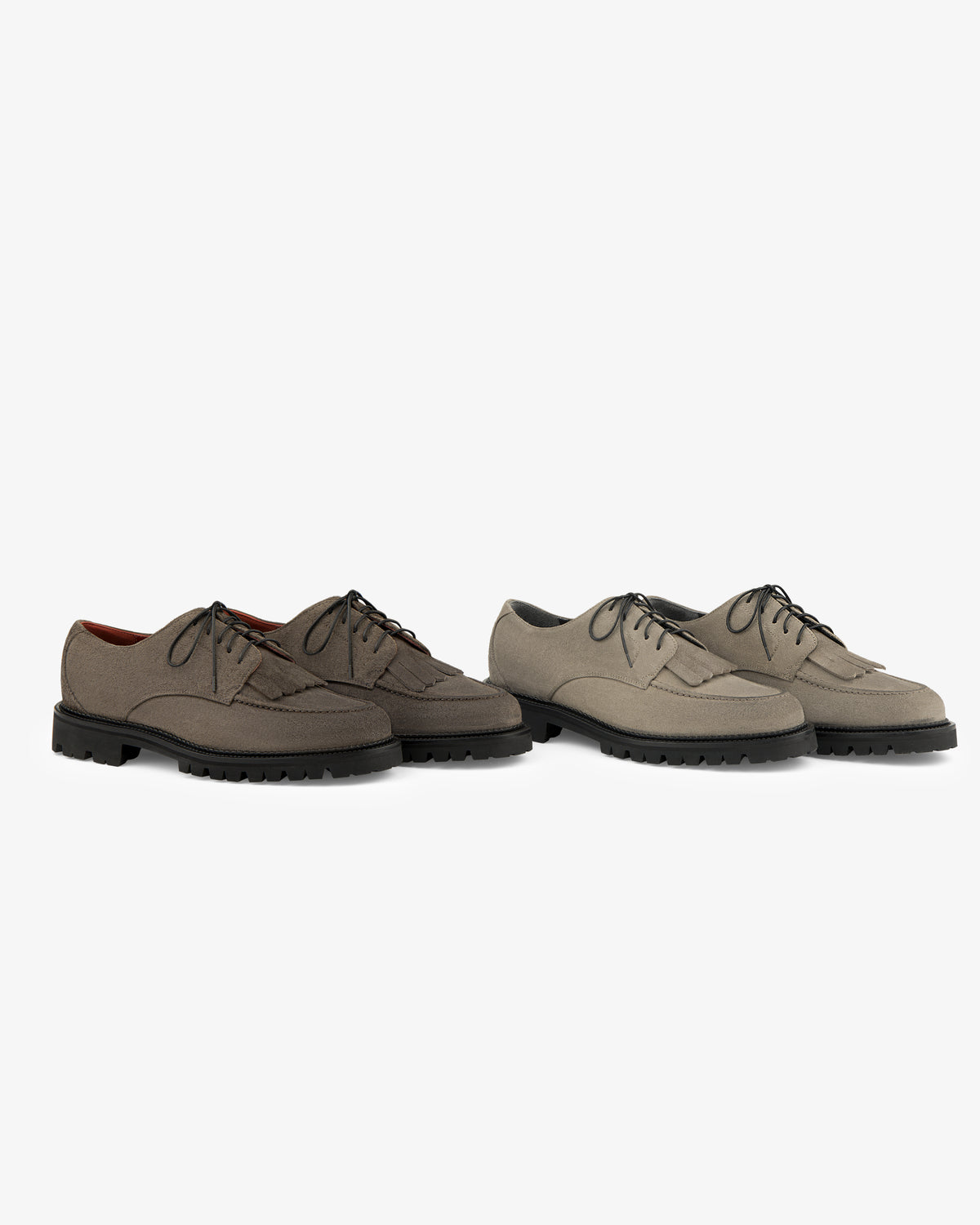 Two Suede Lug Sole Derby shoes in brown and taupe with black soles, displayed on a white background.