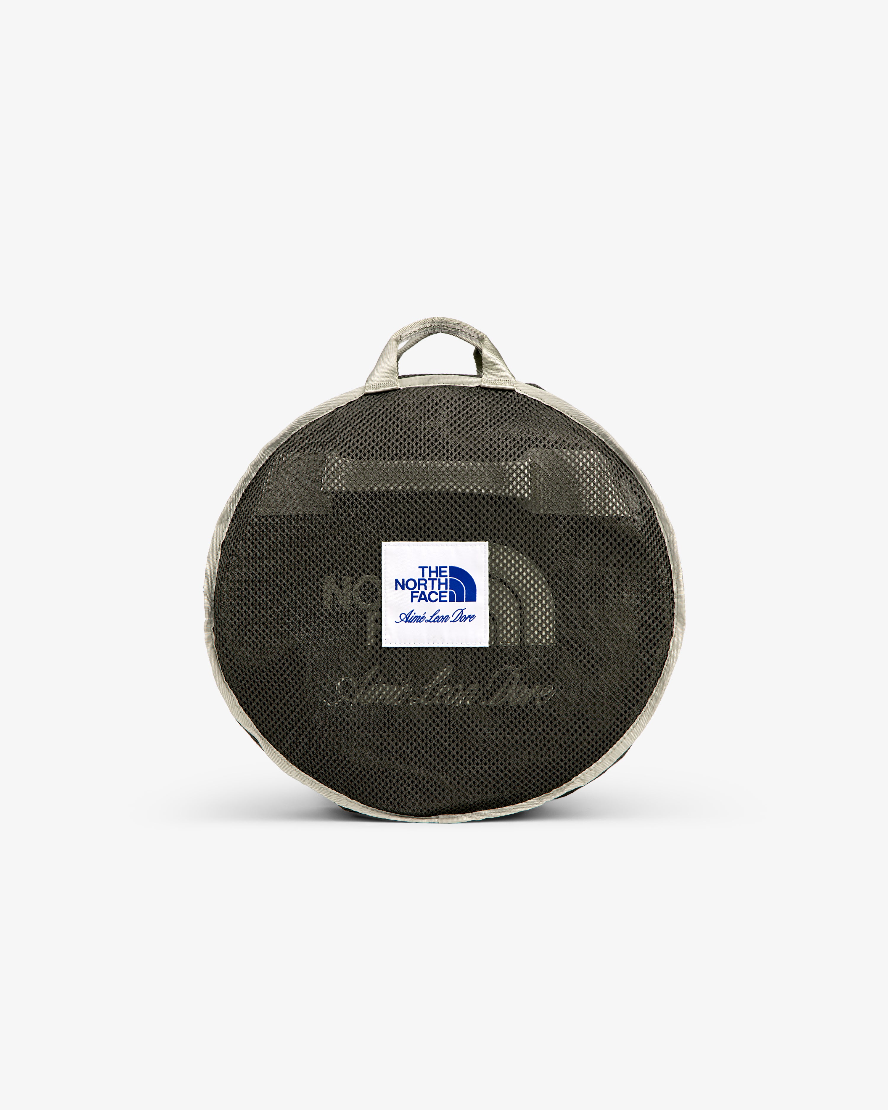 ALD / The North Face Base Camp Duffel: round mesh bag with logo patch, beige trim, and two handles, on white backdrop.