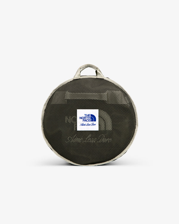 ALD / The North Face Base Camp Duffel: round mesh bag with logo patch, beige trim, and two handles, on white backdrop.