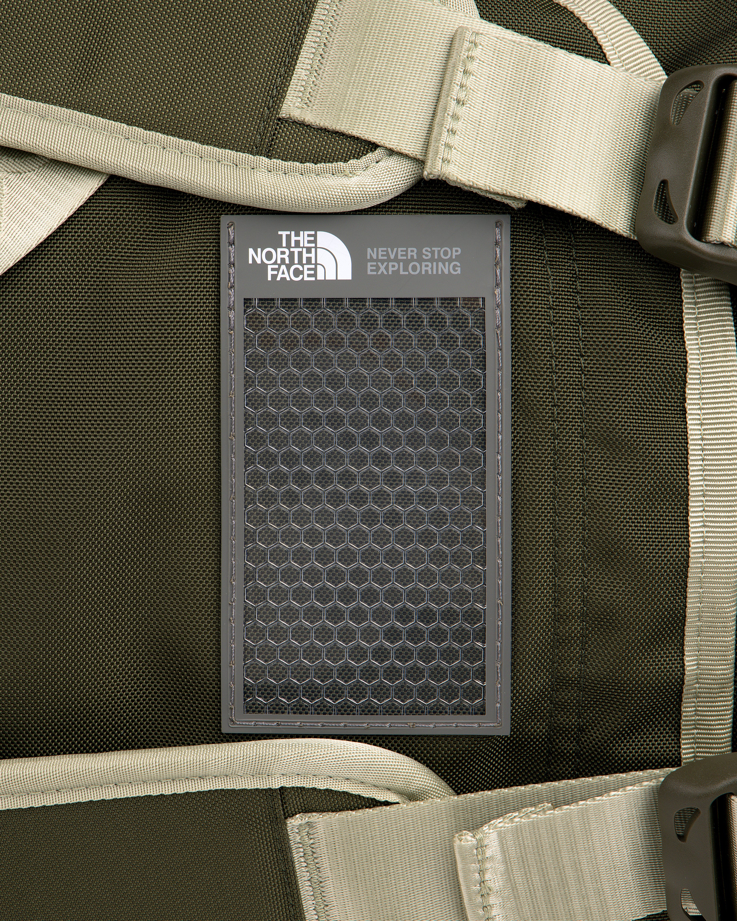 Close-up of ALD / The North Face Base Camp Duffel in green with beige straps and signature patch attached.