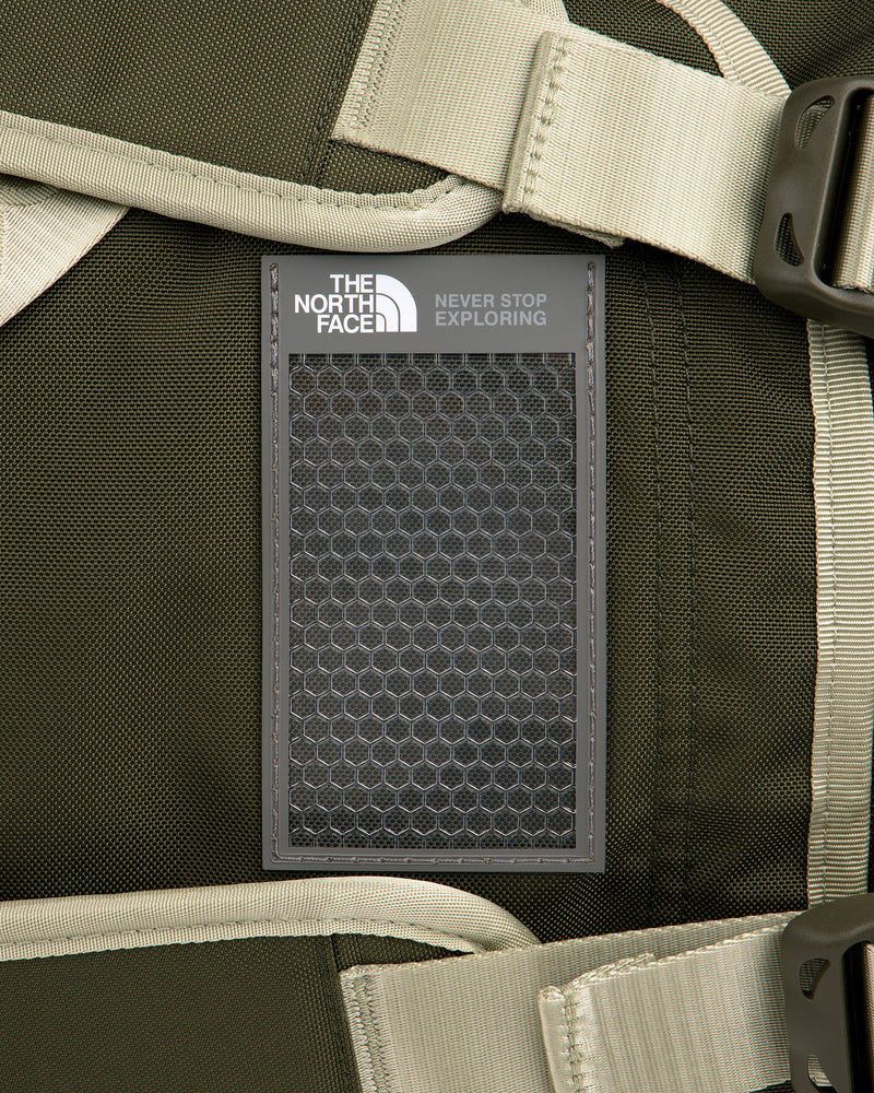 Close-up of ALD / The North Face Base Camp Duffel in green with beige straps and signature patch attached.