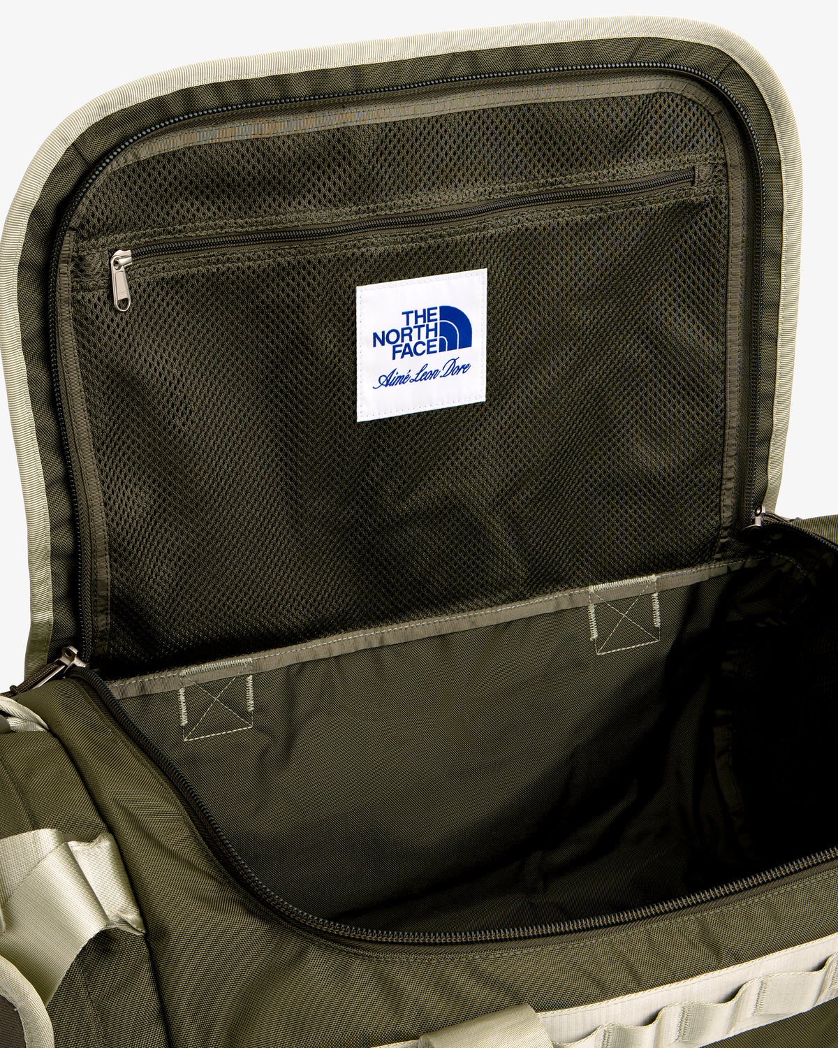 Open green ALD / The North Face Base Camp Duffel with mesh zip lid pocket and white label inside the lid.