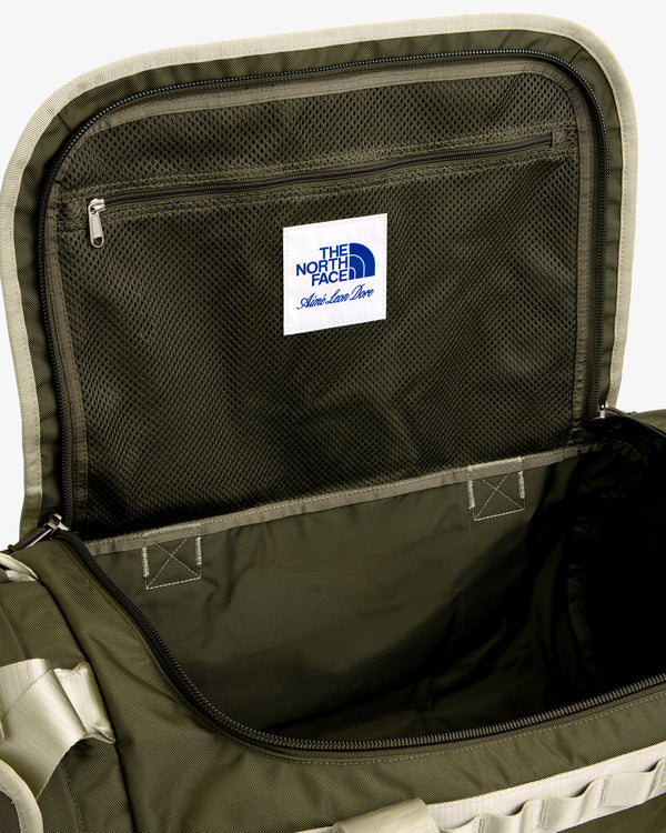 Open green ALD / The North Face Base Camp Duffel with mesh zip lid pocket and white label inside the lid.